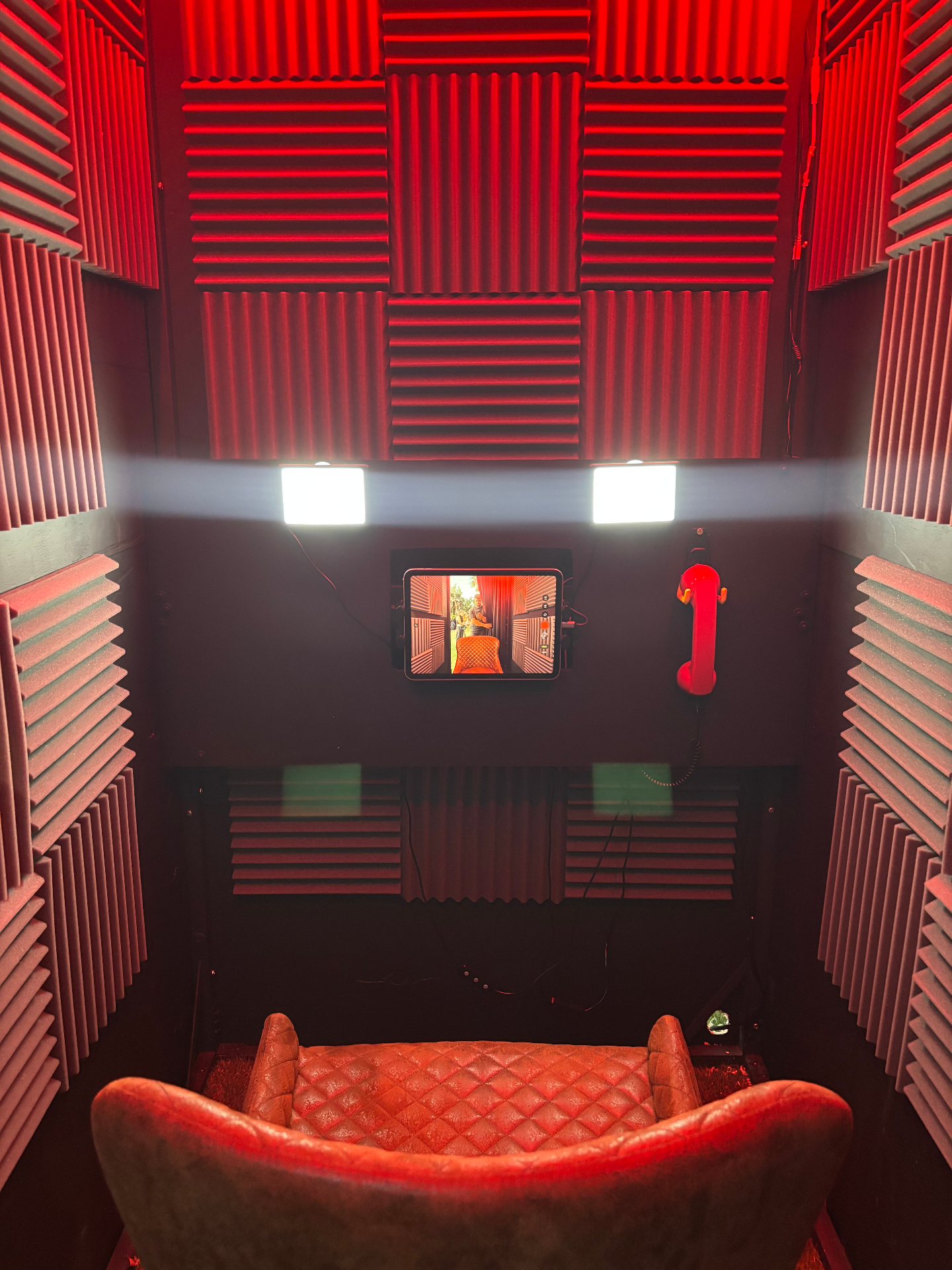 Interior de la cabina de vídeo confesionario con teléfono rojo para barra libre en Andalucía